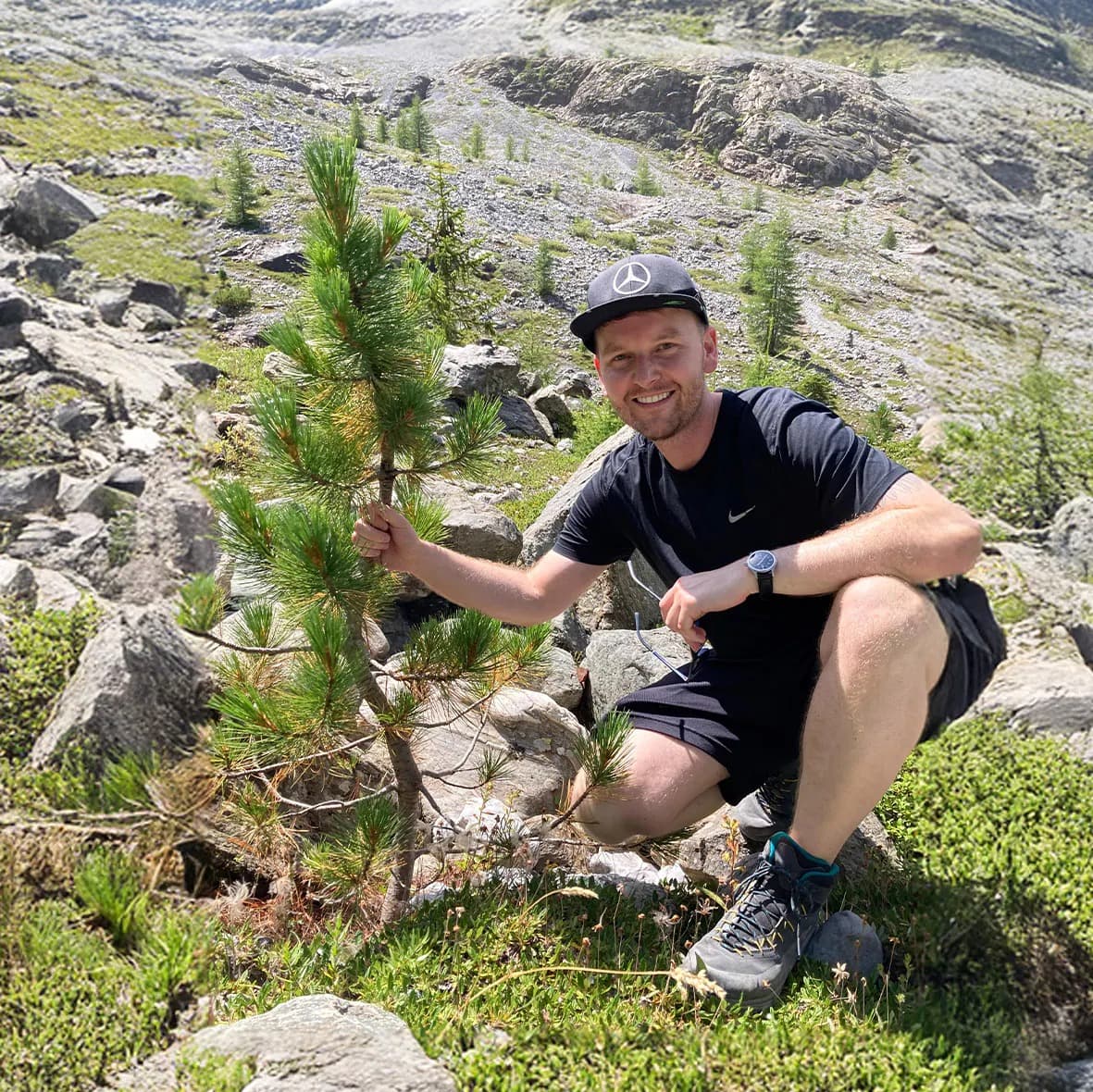 Daniel Abart pflanzt ein Zirbenbäumchen am Berg